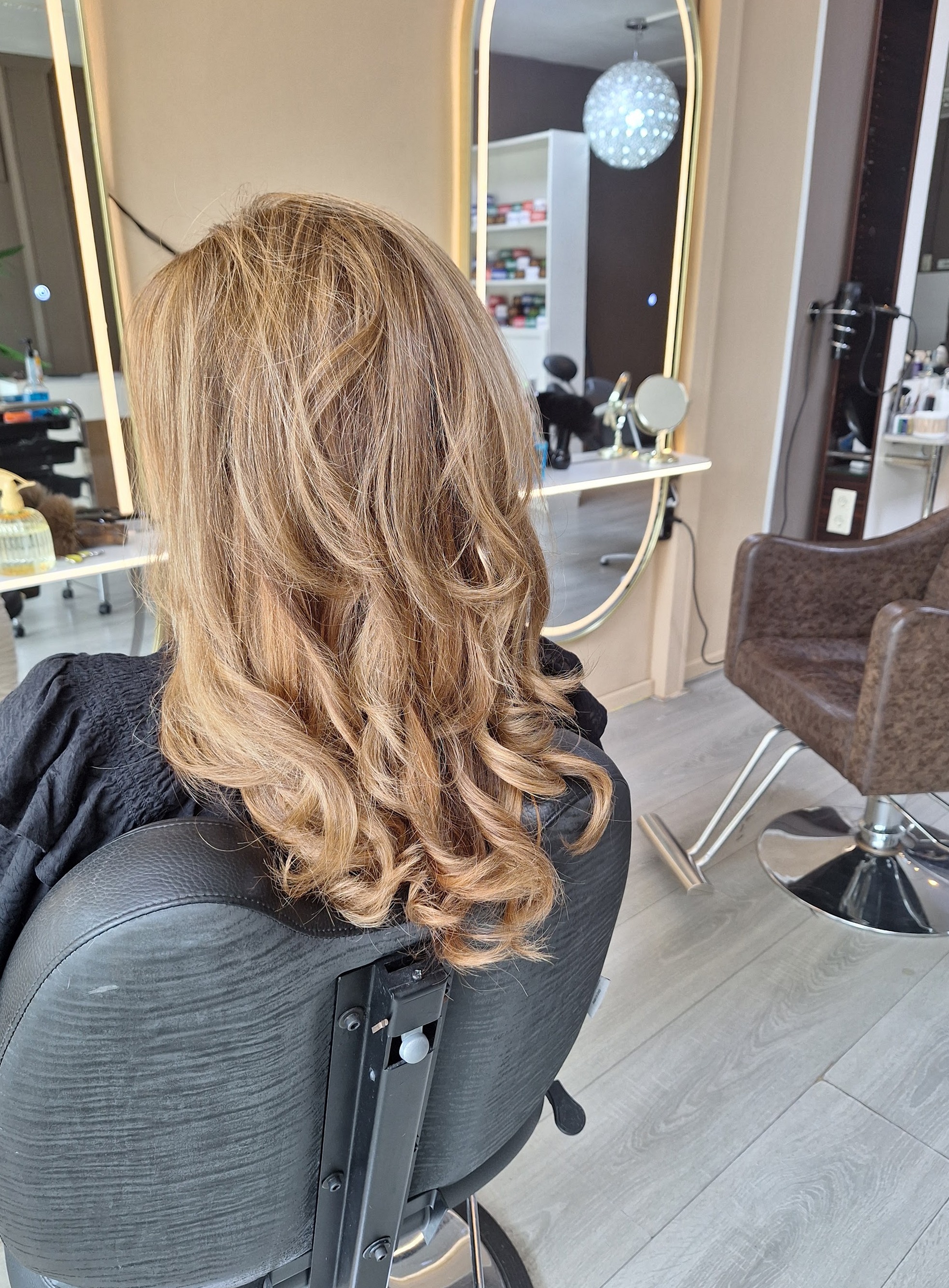 Halflang haar met blonde krullen, in de kappersstoel