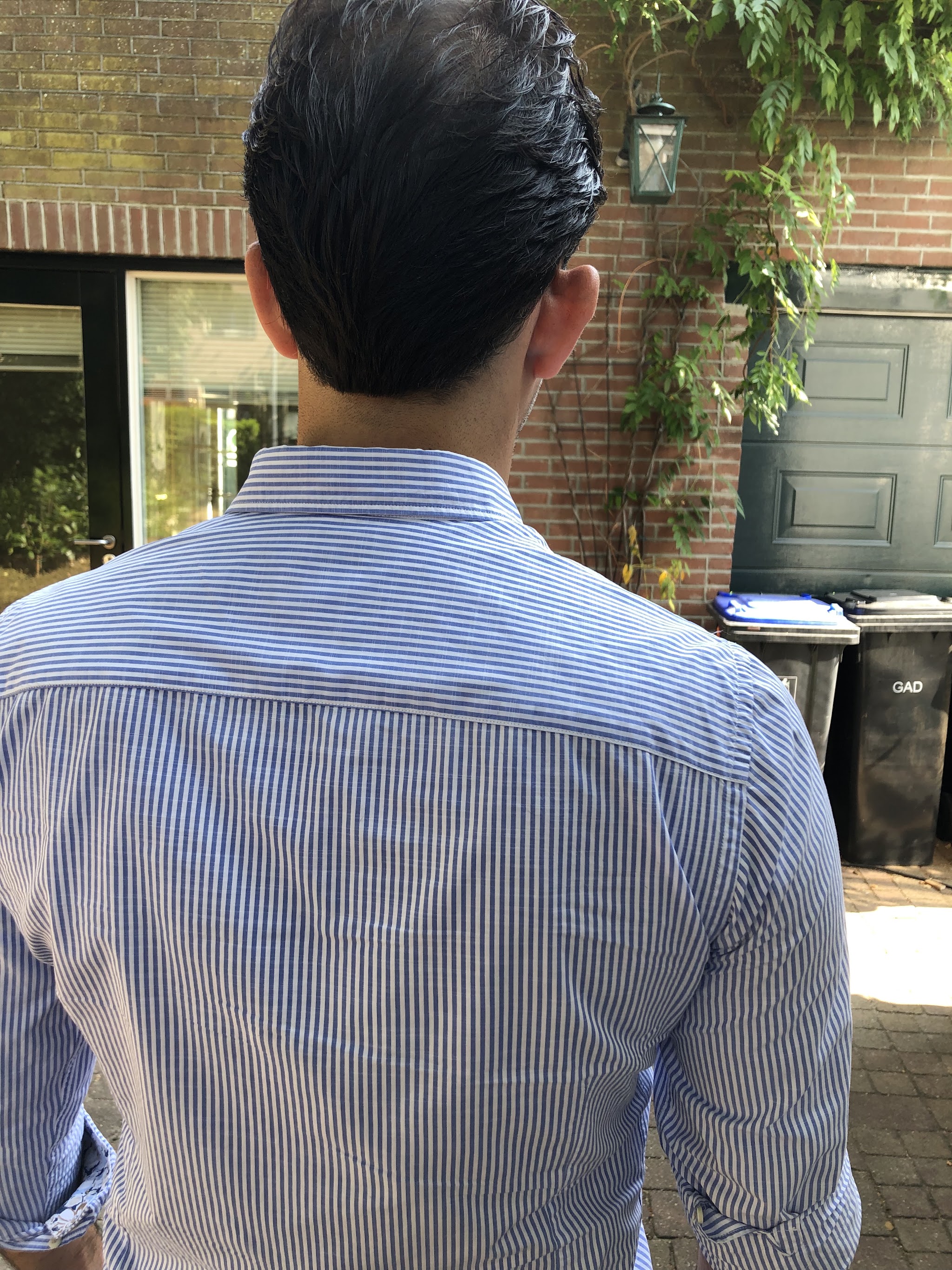 Herenknipbeurt van achteren gezien: kort opgeknipt donker haar
